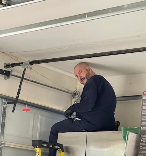 Cesar on a ladder working a customer's garage door in Cypress, TX