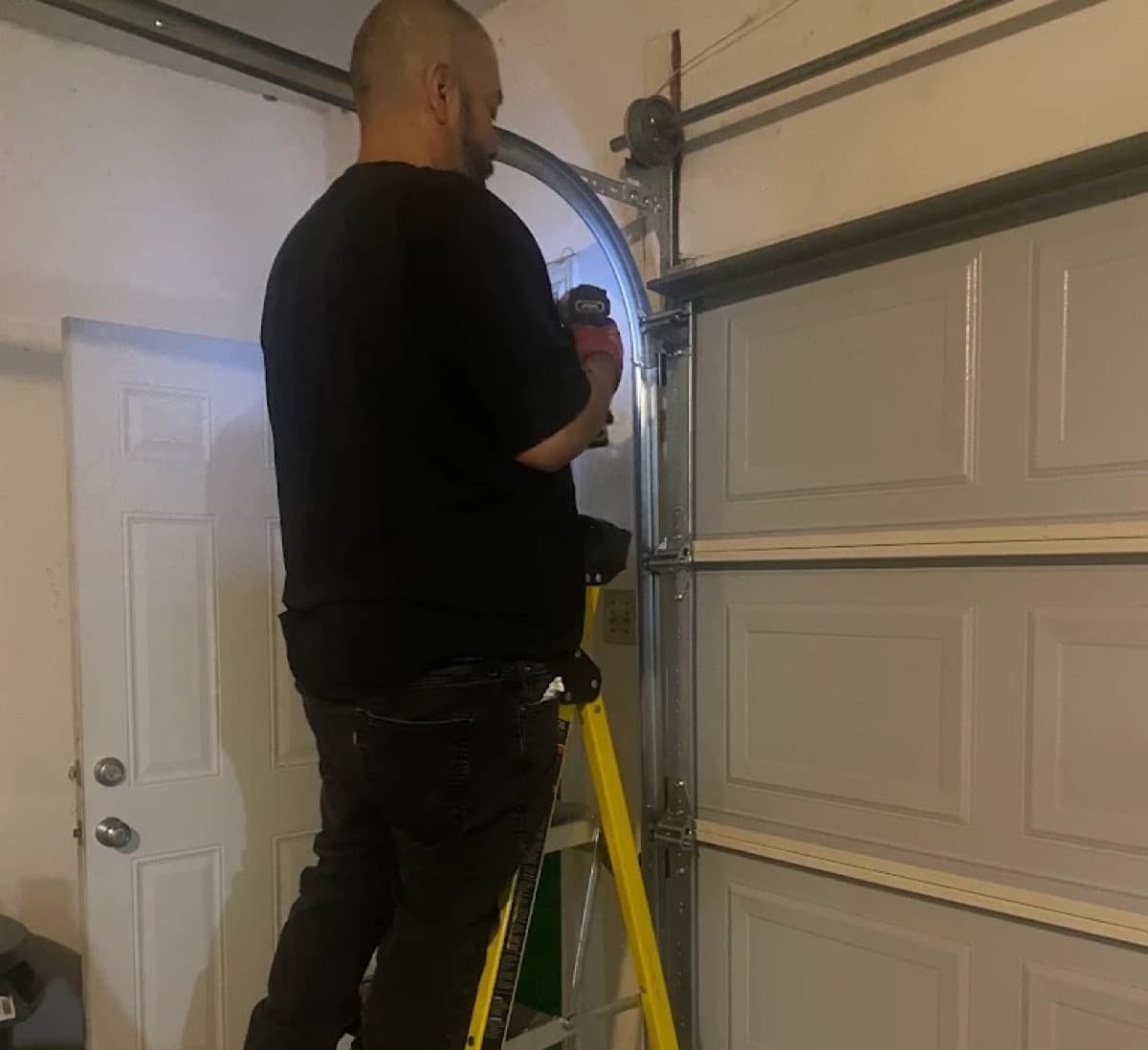 Cesar replacing a garage door spring with a power drill